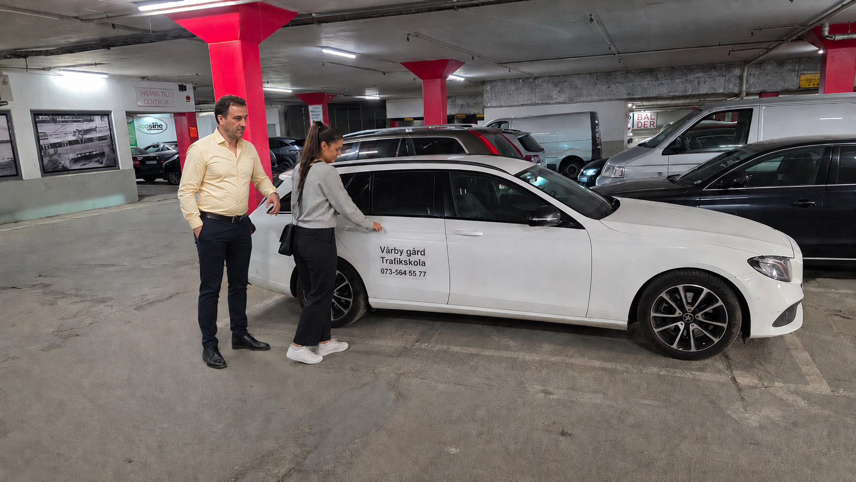 Driving instructor helping a student by the car